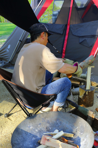 羽鳥湖畔オートキャンプ場で焚き火を準備している男性