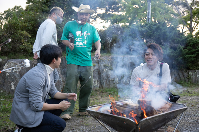 亀山温泉リトリートの焚き火リトリートでマシュマロを焼く男性たち