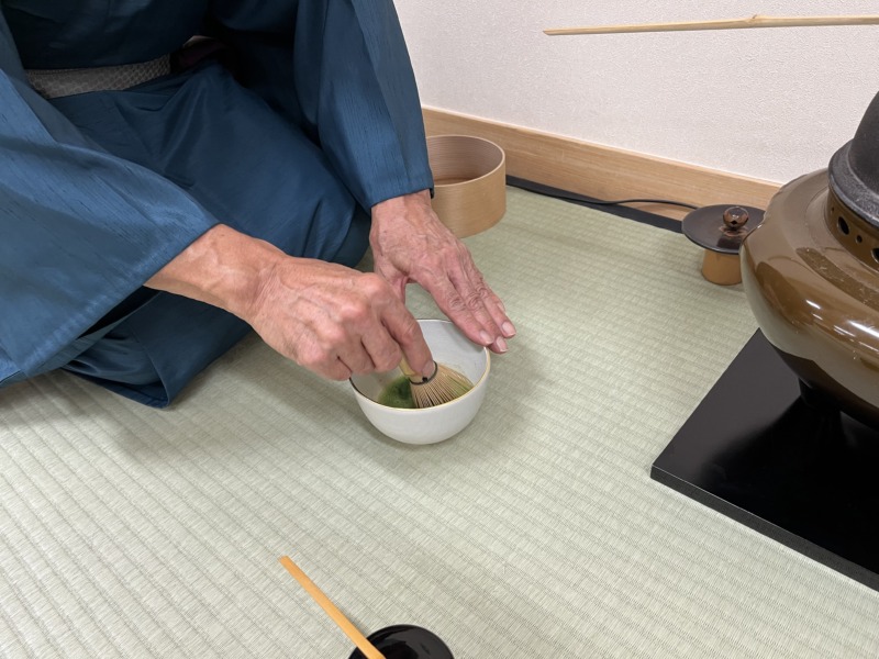 「三徳庵 大日本茶道学会」の茶道教室でお茶の点て方を学ぶ男性